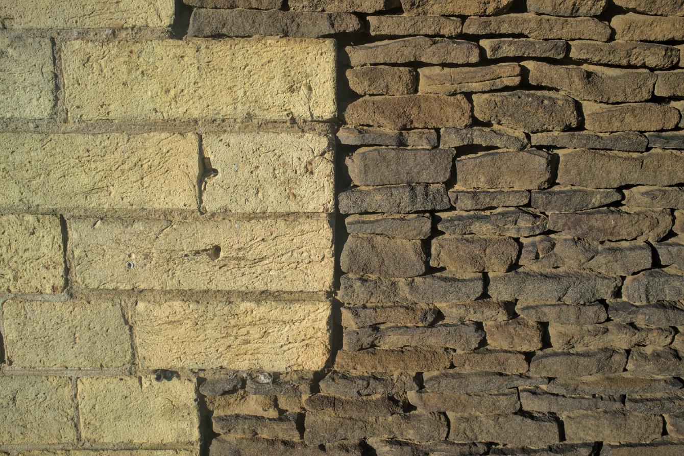 Close-up of some carrstone walls of the station building, with clay brick corners.