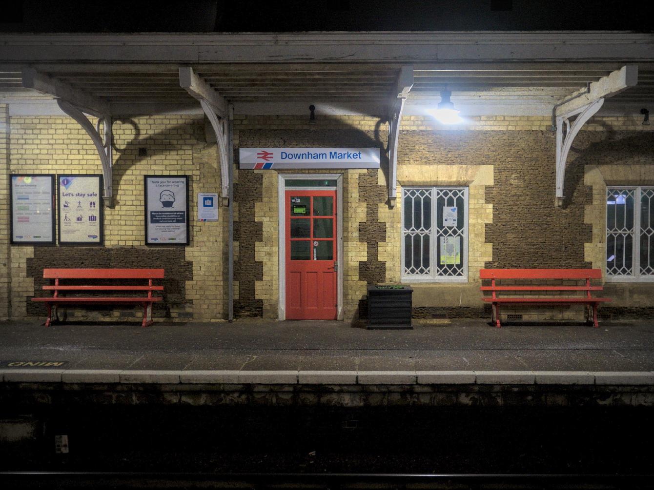 A view from Platform 2 across to the brick-built station building on Platform 1, with a Network SouthEast sign for Downham Market above a door.