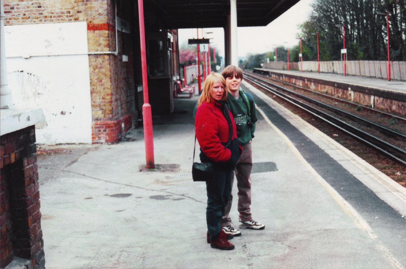 A 1990s photo of me and my mum at some railway station in Kent.