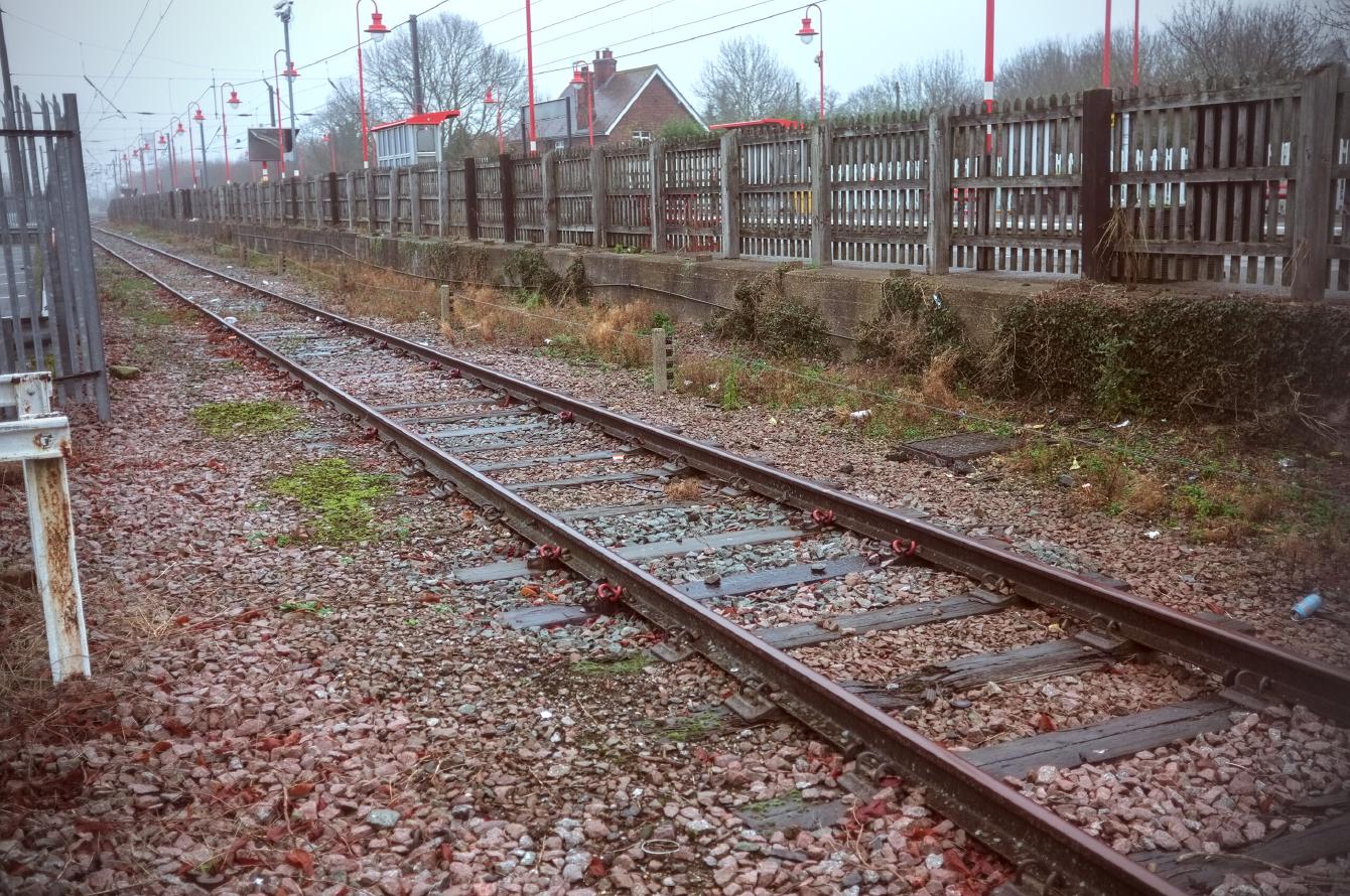 A view of the siding at Downham Market. It is a single track surrounded by fences.