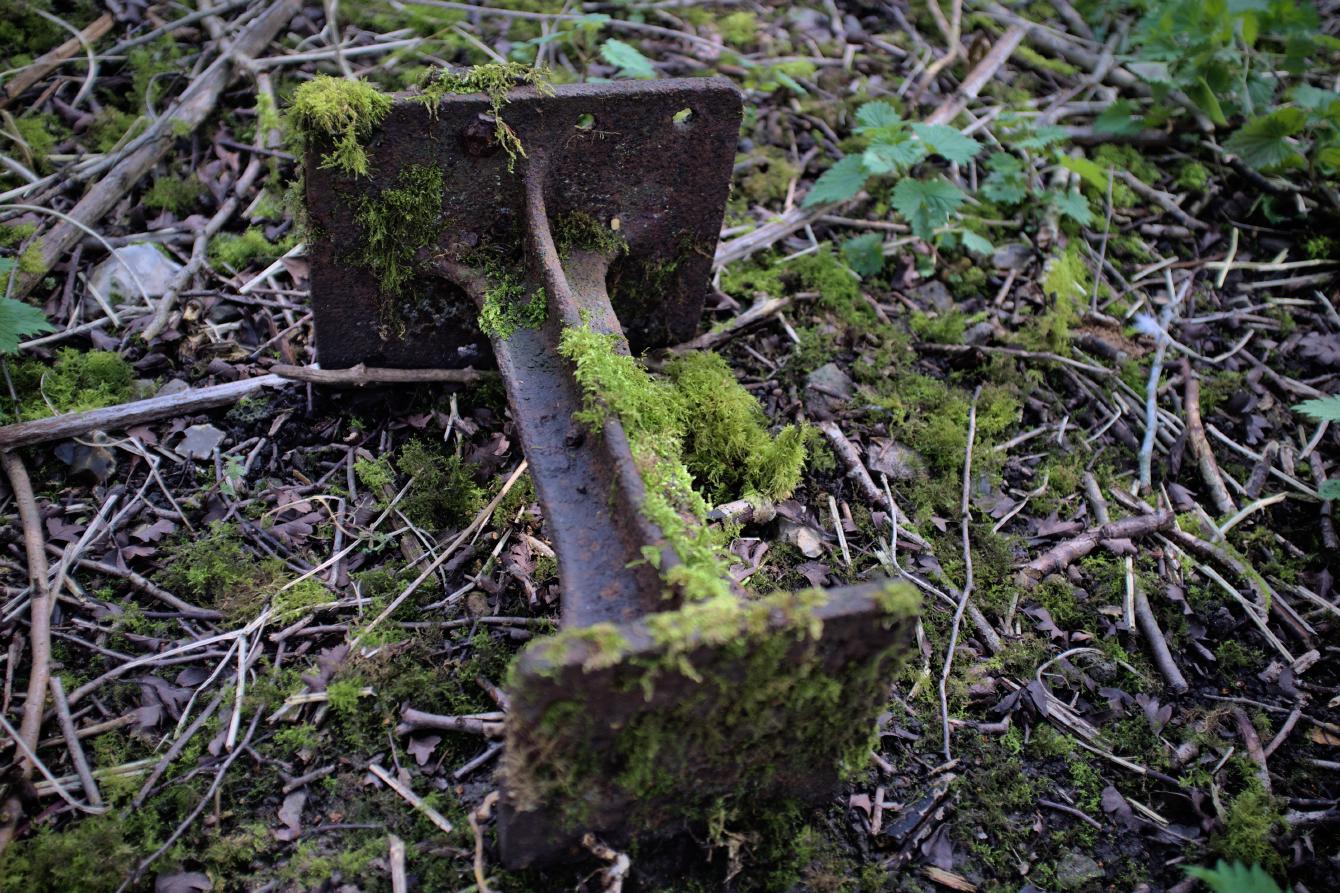 A bracket lying on the ground; it is flat top and bottom, and has a connecting piece in the middle.
