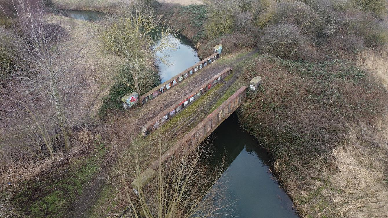 An aerial photo of the bridge taken from a drone, showing the vegetation building up on the east bank on the right of the photo.