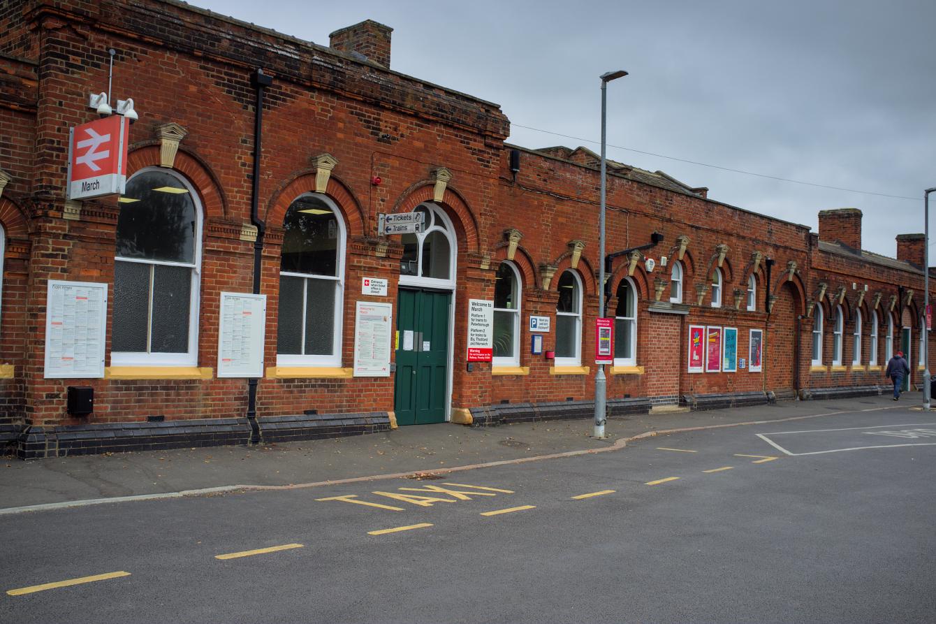 The outside of March station building in 2023. The construction clutter has disappeared, and two &ldquo;Tickets&rdquo; and &ldquo;Trains&rdquo; signs, in British Rail style, have re-appeared.
