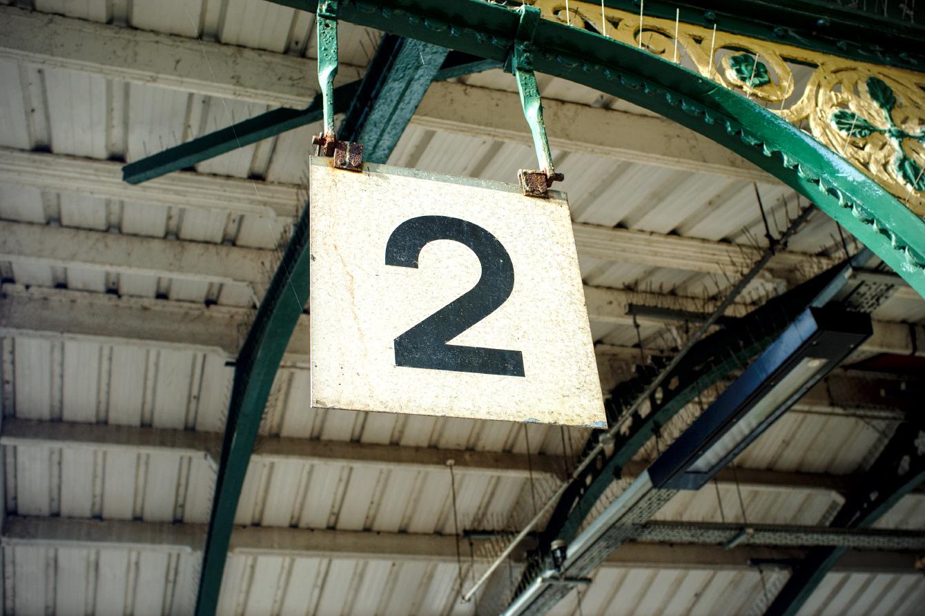 The &ldquo;2&rdquo; sign at platform 2 on March railway station. It is a simple number 2 on a square background measuring, at a guess, about 40 centimeters on each side.