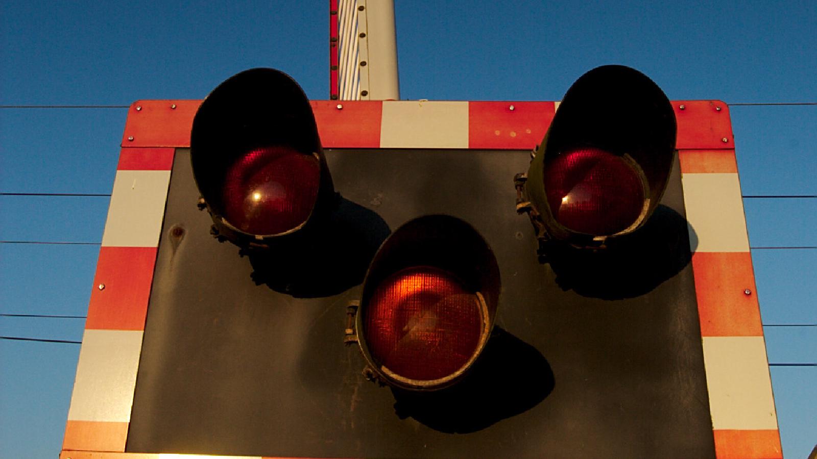 Close-up of some crossing barrier lights against a dark blue sky.