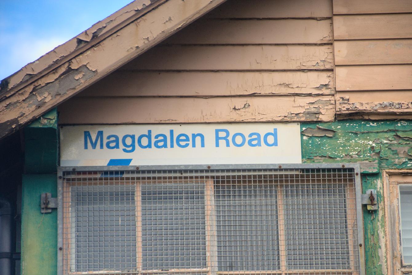 A Network SouthEast branded sign on the signal box reading &ldquo;Magdalen Road&rdquo;.