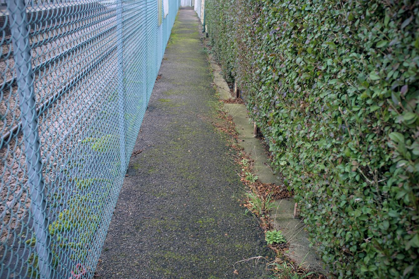 Looking back down the platform, the walkway between the fence on the left and the buildings on the right is about a metre wide.