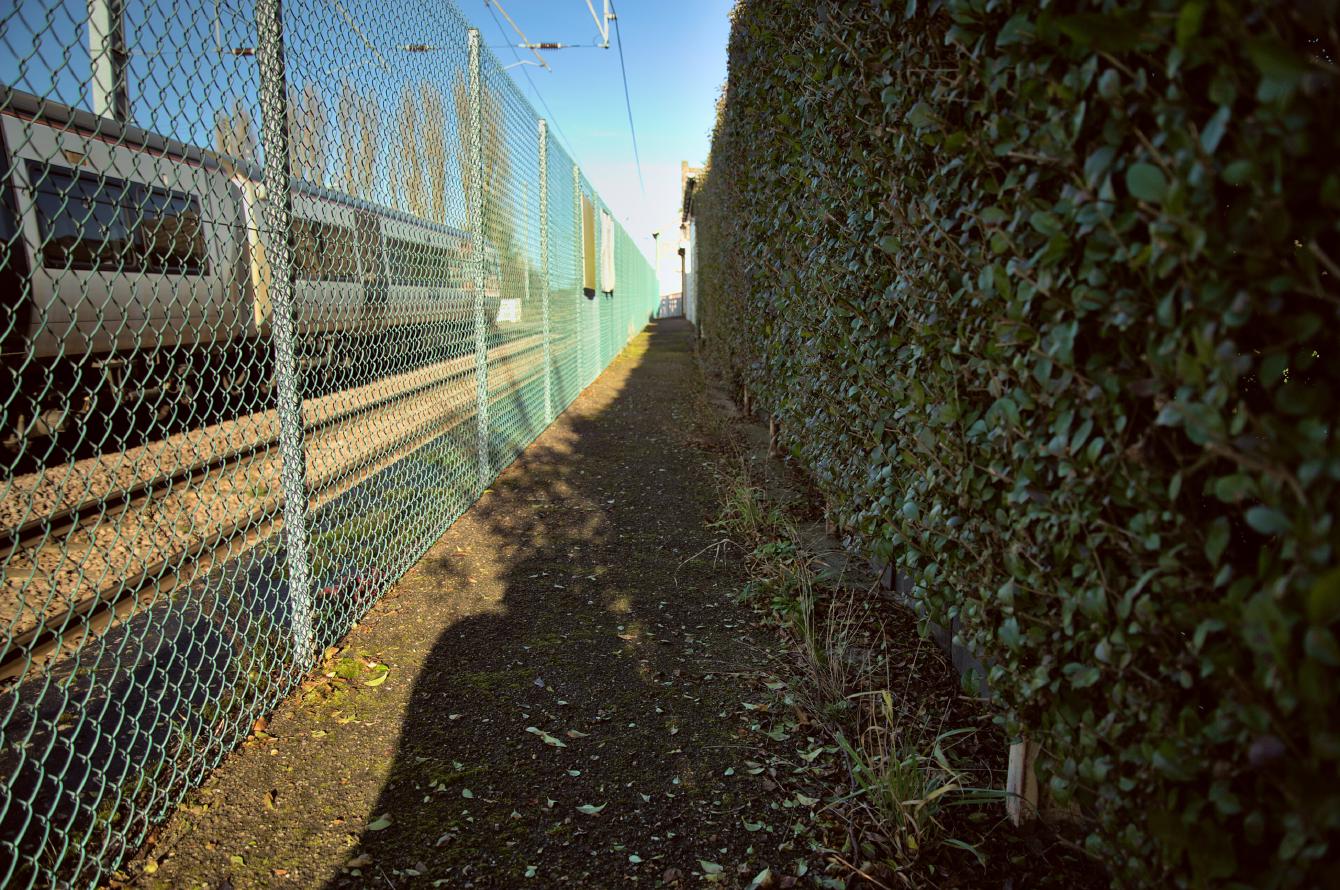 Looking back down the platform, the walkway between the fence on the left and the buildings on the right is about a metre wide.