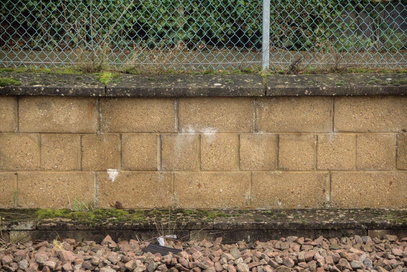 A closeup shows modern concrete blocks forming the face of the old platform.