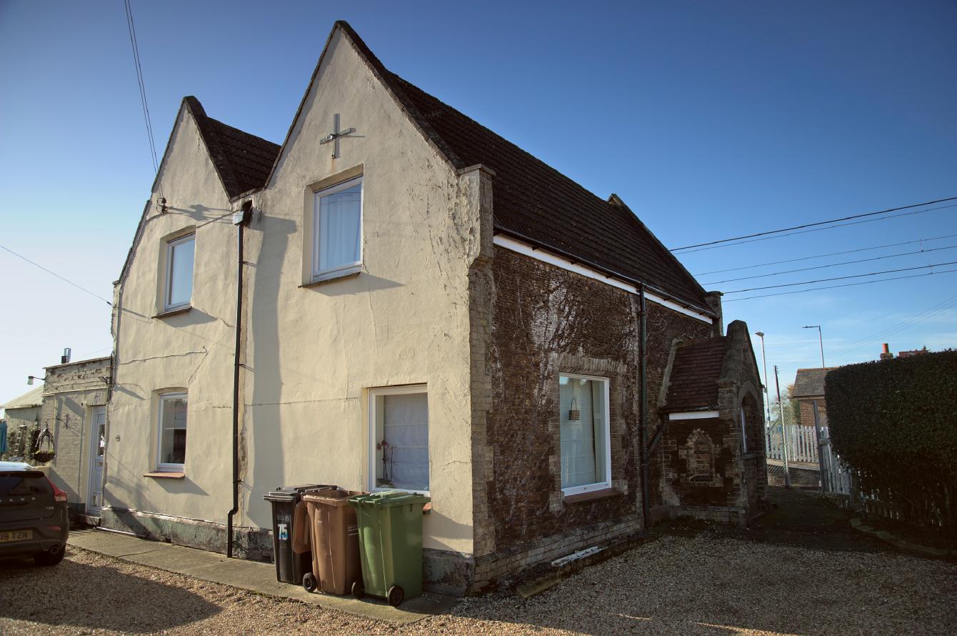An old station house; it is mostly of carrstone construction, with one visible rendered wall.