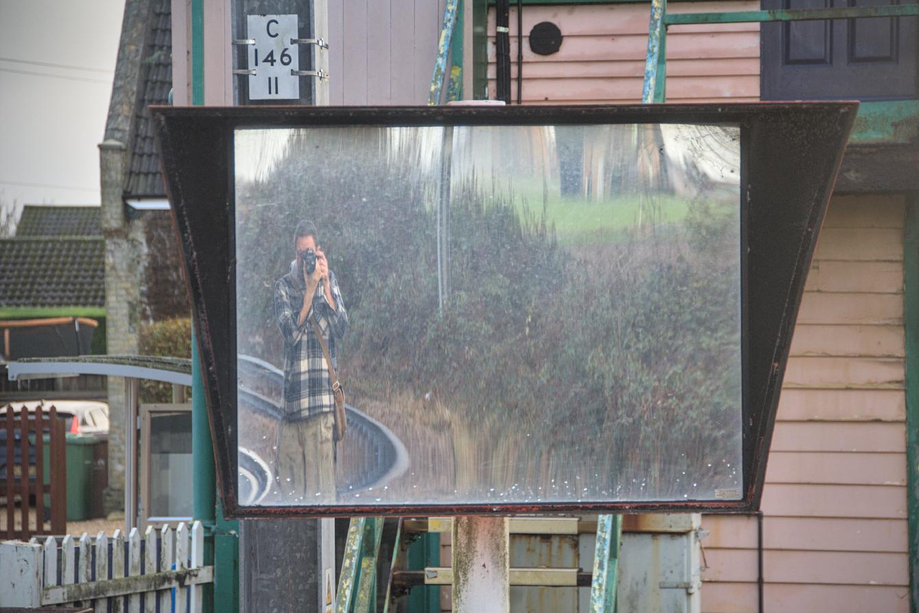 A photograph taken into a very large, somewhat wavy mirror.