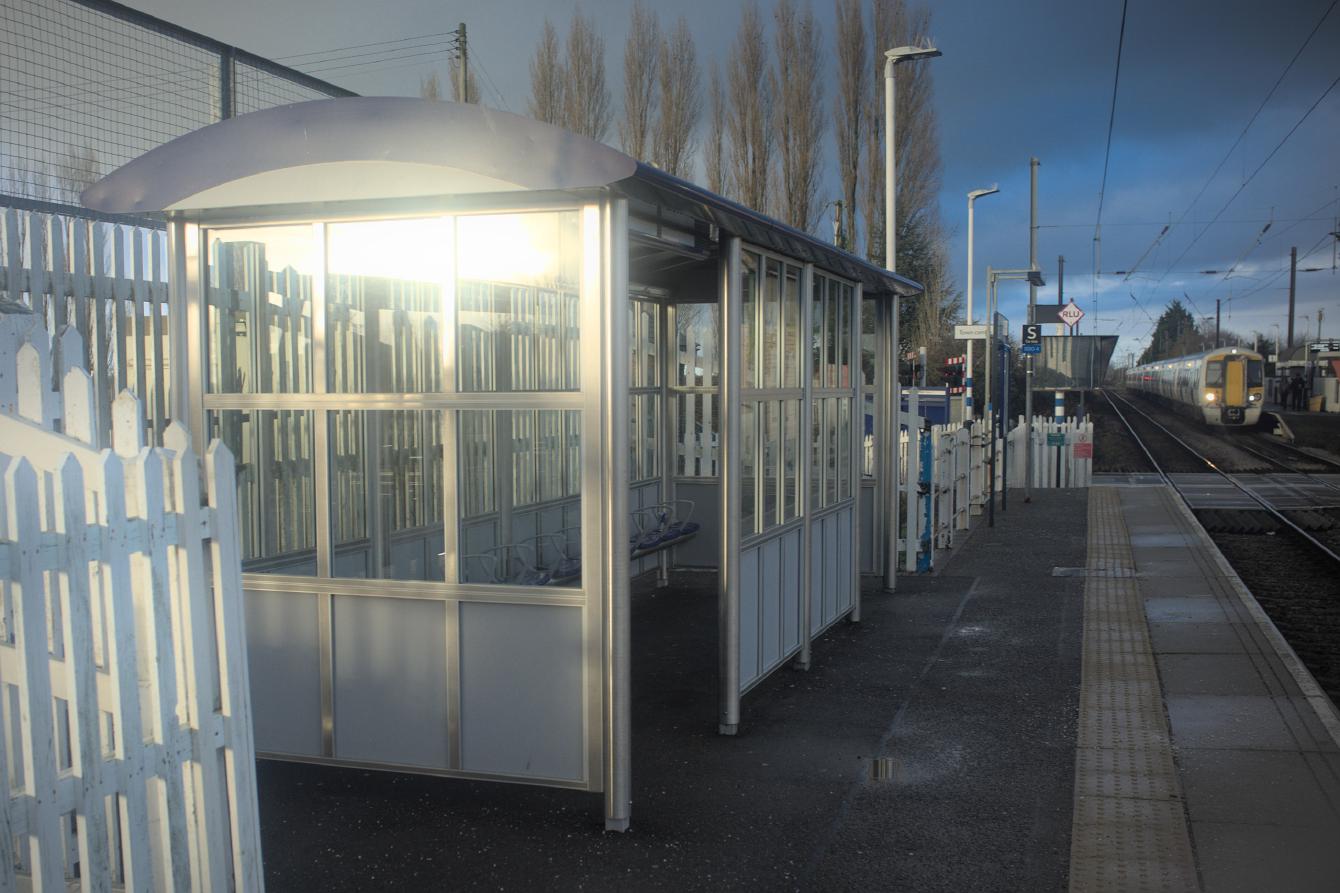A platform shelter made mostly of a steel frame, with glass on all sides.