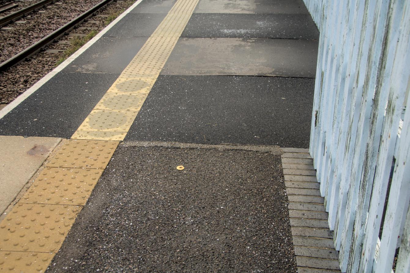 A change in surface on the face of the platform; asphalt turns to weatherproofed plywood.