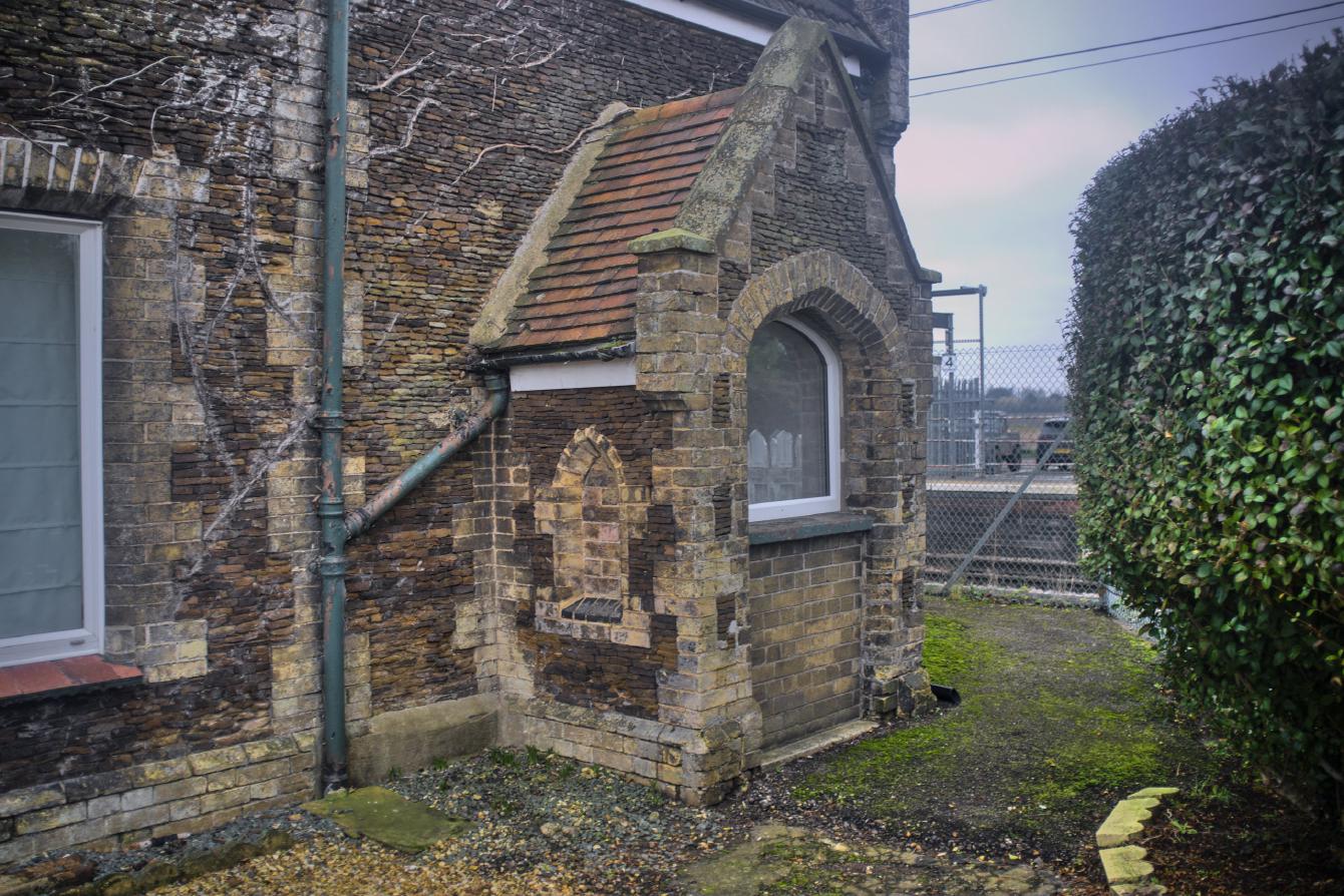 A brick-built doorway extending outwards from the building by about a metre; it has clay roof tiles.